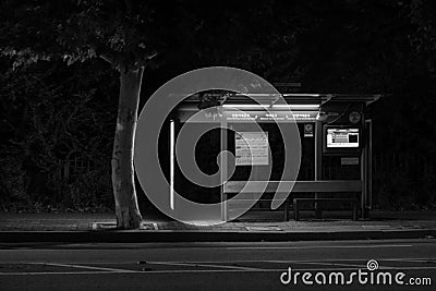 Black and white picture of the bus stop at a late hour. Stock Photo