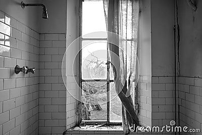 Black and white picture of a depressive dirty bathroom in an abandoned house of Chernobyl. Broken window with old curtain. Stock Photo