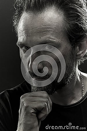 Black and white portrait of a beardy man with serious look on his face. Stock Photo