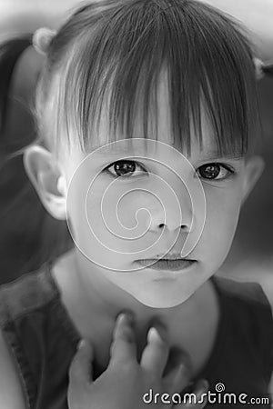 Portrait of an emotional 3-year-old girl with black expressive eyes Stock Photo