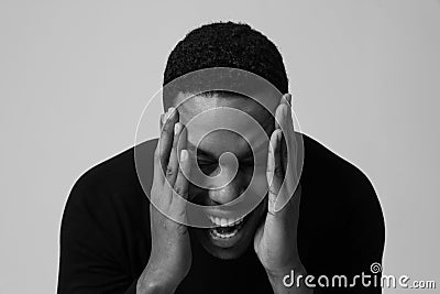 Black and white portrait of Black guy stressing and headache. Mental issues. Stock Photo