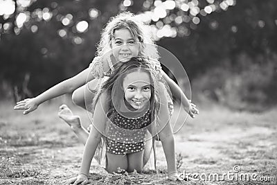 Black and white portrait of Two Cute little girls playing and laughing at the countryside. Happy kids outdoors concept Stock Photo