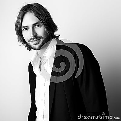 Black-white portrait of young handsome long hair man against studio background Stock Photo