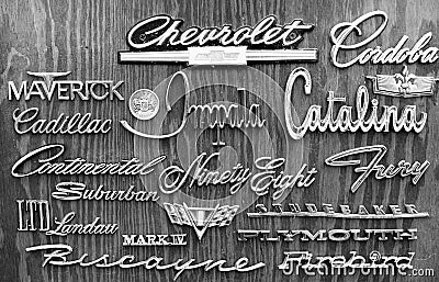 Black and white shot of American car brand name badge logos attached to wooden wall as art in a bar Editorial Stock Photo