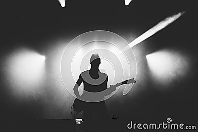 Black and white shot of guitarist silhouette in a stage backlights Stock Photo