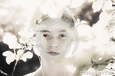 Smiling young man covered of overexposed leaves Stock Photo