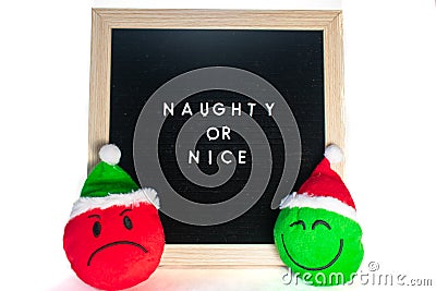 A Sign That Says Naughty or Nice With Christmas Emoticons In Front of It Stock Photo