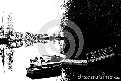 Black and white silhouette of rowboats moored on a lagoon, trees in distance Stock Photo
