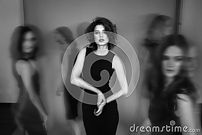 Black and white studio photo of five women in black dresses. Blu Stock Photo