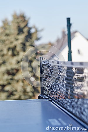 Black and white table tennis net from the side over blue outdoor plate, vertical photo Editorial Stock Photo