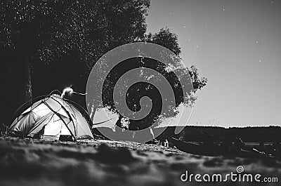 Black and white tent on the beach; camping under full moon Stock Photo