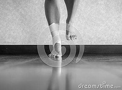 Black and white version of Athlete balancing to regain proprioception on sprained ankle Stock Photo