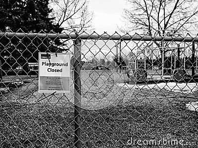 Black and white version of Closed Playground sign on a fence due to Covid 19 pandemic Editorial Stock Photo