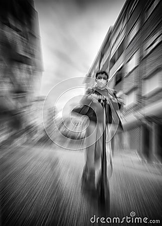 Black and white zooming moving image of a child with a mask riding an electric scooter at full speed Editorial Stock Photo