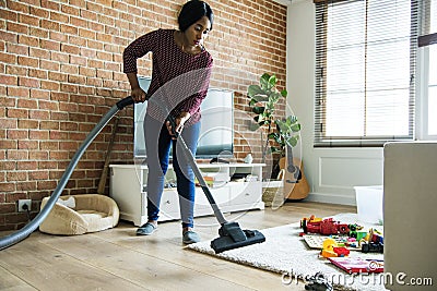 Black woman is cleaning living room Stock Photo