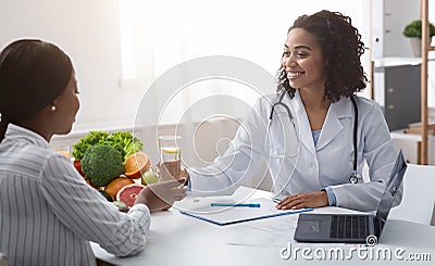 Black woman dietician consulting patient, using laptop Stock Photo