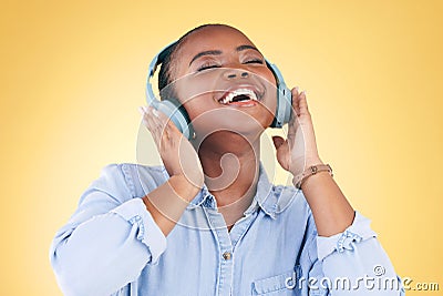 Black woman, happiness and headphones with music, energy and audio streaming isolated on yellow background. Sound Stock Photo