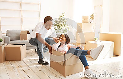 Black woman and her boyfriend playing together with cardboard box during relocation Stock Photo