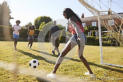 Black woman saving goal during a game of football in garden Stock Photo