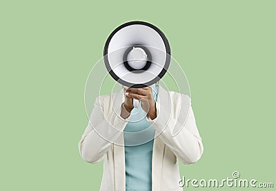 Black woman shouting through megaphone and making announcement with her loud voice Stock Photo