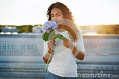 Black woman smelling a pretty flower Stock Photo