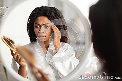 Black Woman Suffering Hairloss Problem, Holding Comb With Lot Of Fallen Hair Stock Photo