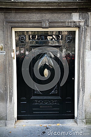 Black wooden door in typical Dutch style in old streets of Amsterdam, The Netherlands, October 13, 2017 Stock Photo