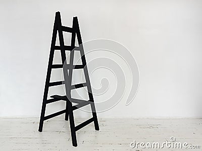 Black wooden stepladder in interior Stock Photo