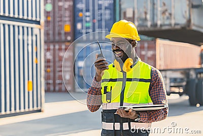 Black worker African working engineer foreman radio control in port cargo shipping customs container yard Stock Photo