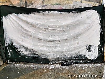 Black woven fabric painted with white paint on the facade of the building Stock Photo