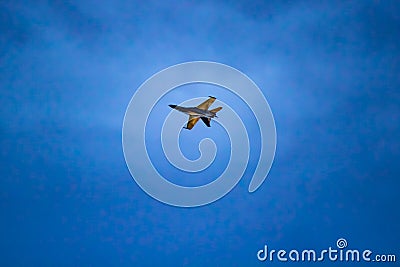 A black and yellow fighter jet performing aerial maneuvers solo Stock Photo