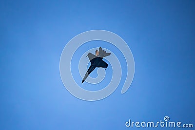 A black and yellow fighter jet performing aerial maneuvers solo Stock Photo