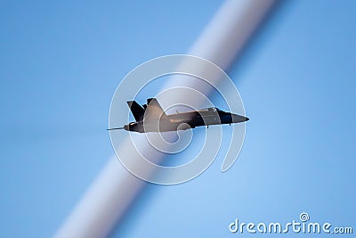 A black and yellow fighter jet performing aerial maneuvers solo Stock Photo