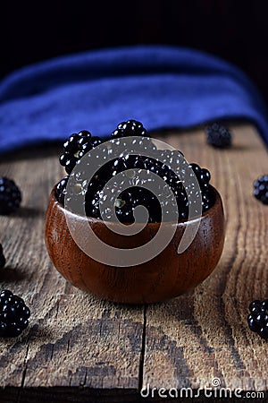 Blackberries in a wooden bowl on the wooden table Stock Photo