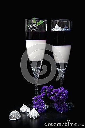 Blackberry panna cotta in glasses on a black background Stock Photo