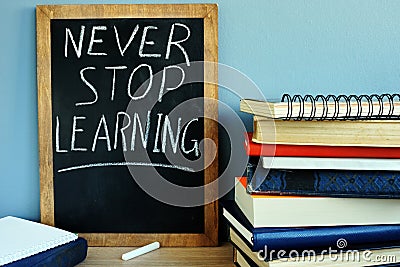 Blackboard with Never stop learning and books. Stock Photo