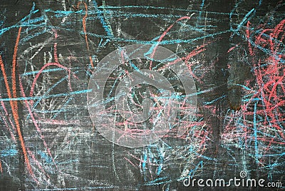 The blackboard is randomly painted with bright colored crayons. Children`s drawings Stock Photo