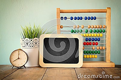 Blackboard, stack of colorful beaded abacus and clock. back to school concept Stock Photo