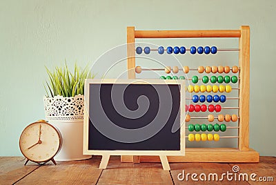 Blackboard, stack of colorful beaded abacus and clock. back to school concept Stock Photo