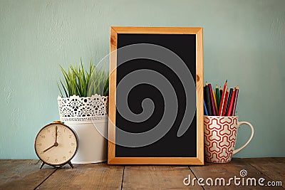 Blackboard, stack of colorful pencils and clock. back to school concept Stock Photo