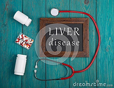 Blackboard with text & x22;Liver disease& x22;, pills and stethoscope on wooden background Stock Photo