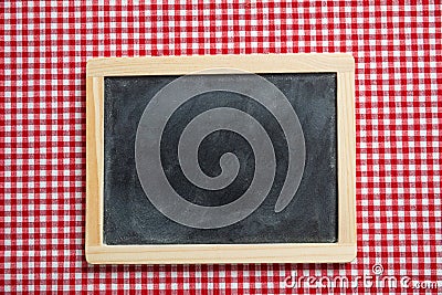 Blackboard with wooden frame on red checkered picnic tablecloth, copy space Stock Photo