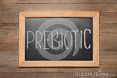 Blackboard with word Prebiotic on wooden table, top view Stock Photo