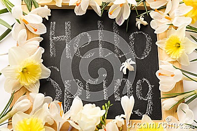 Blackboard with words HELLO SPRING and fresh flowers on white background, flat lay Stock Photo