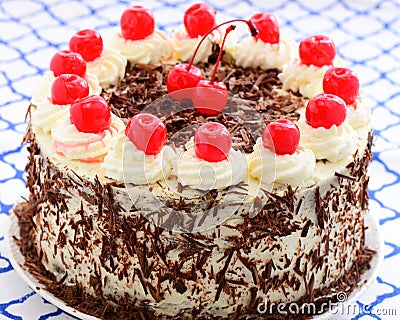 Blackforest gateau decorated with the traditional cream, chocolate flakes and cherries Stock Photo