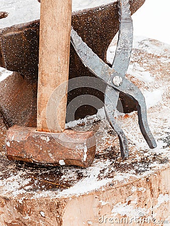 Blacksmith anvil, tongs and hammer in old smithy Stock Photo