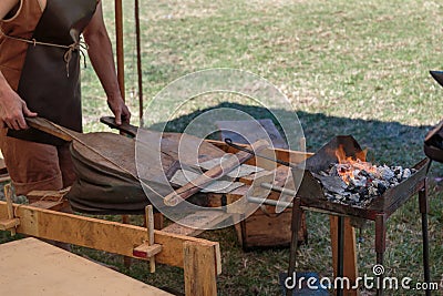 Blacksmith Blows Coals with Bellows, Working Tool Stock Photo