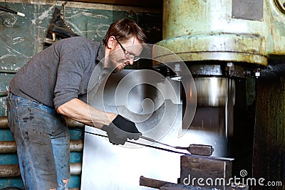 Blacksmith forging by using pneumatic hammer. Stock Photo