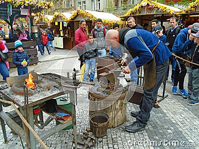 Blacksmith and an old blacksmith work at the Easter markets. Prague, Czech Republic, Editorial Stock Photo