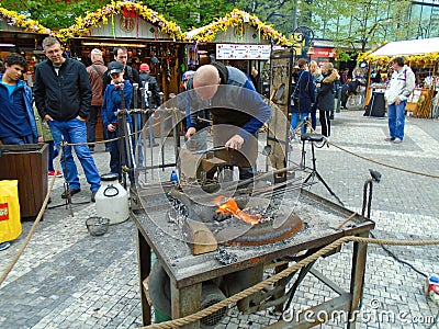 Blacksmith and an old blacksmith work at the Easter markets. Prague, Czech Republic, Editorial Stock Photo